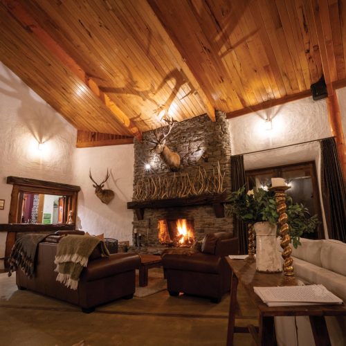 Kuranui Lodge's grand stone fireplace in the main living area.